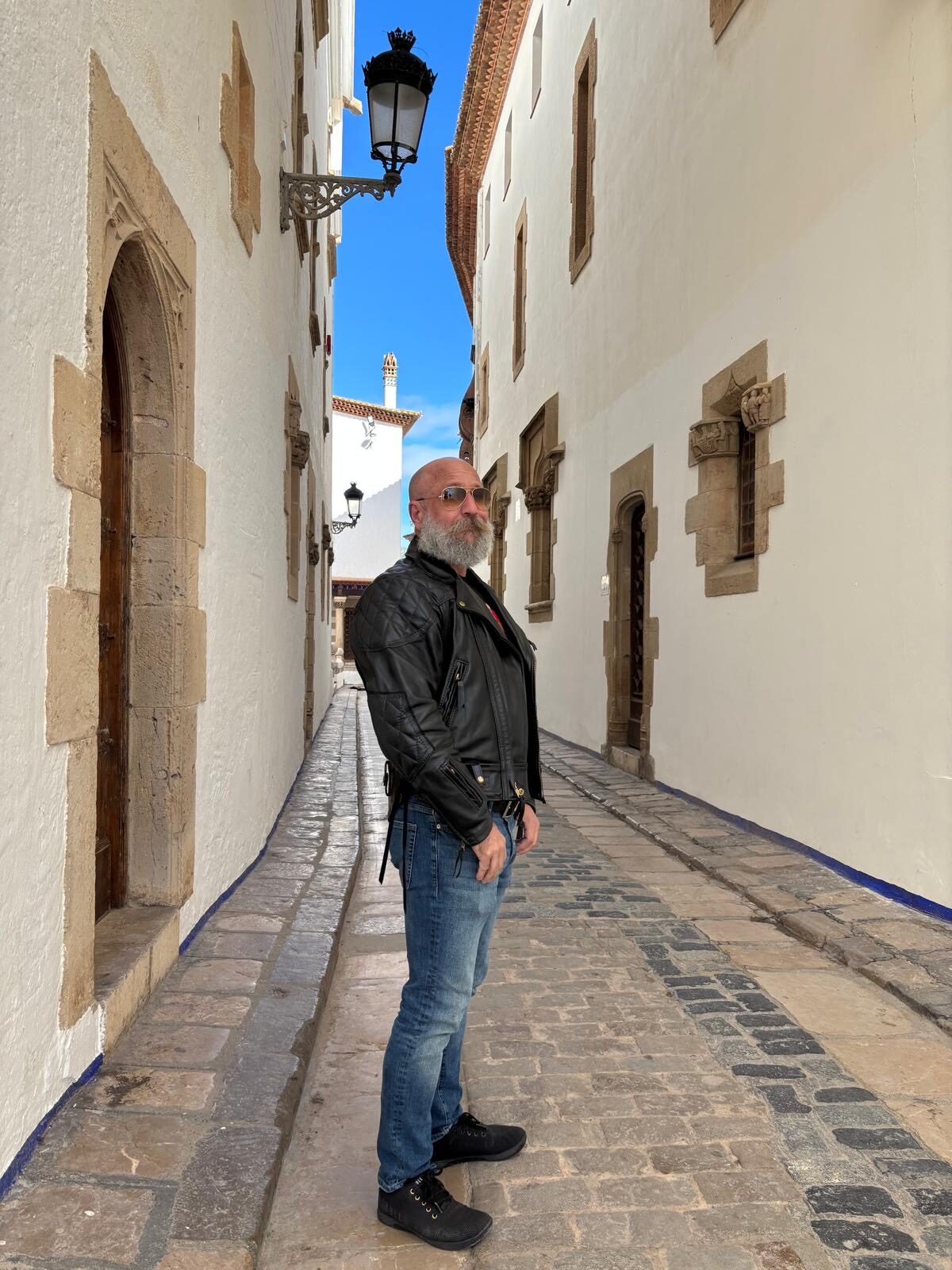 Barclay Barrios walking through a narrow stone alley in Spain.