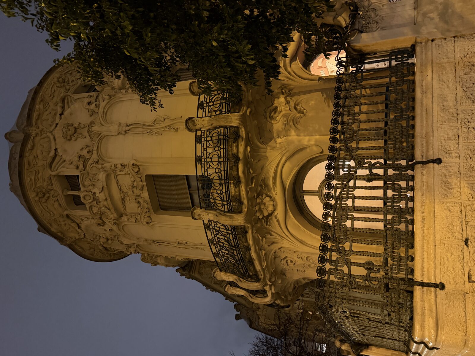 Ornate Art Nouveau building facade at dusk.